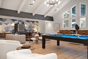 A living room with a pool table and couches